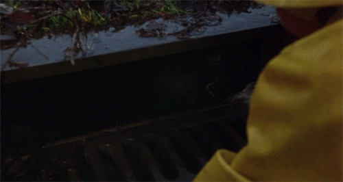 Pennywise from Stephen King's "It" peeking out from sewer